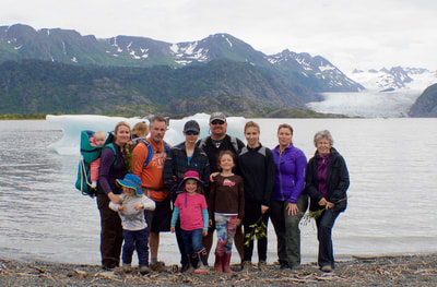 Multi-generational family posing in front of Grewingk Glacier Lake. 